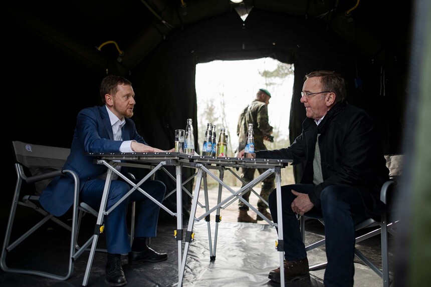 Zwei Männer sitzen in einem Bundeswehrzelt gegenüber.